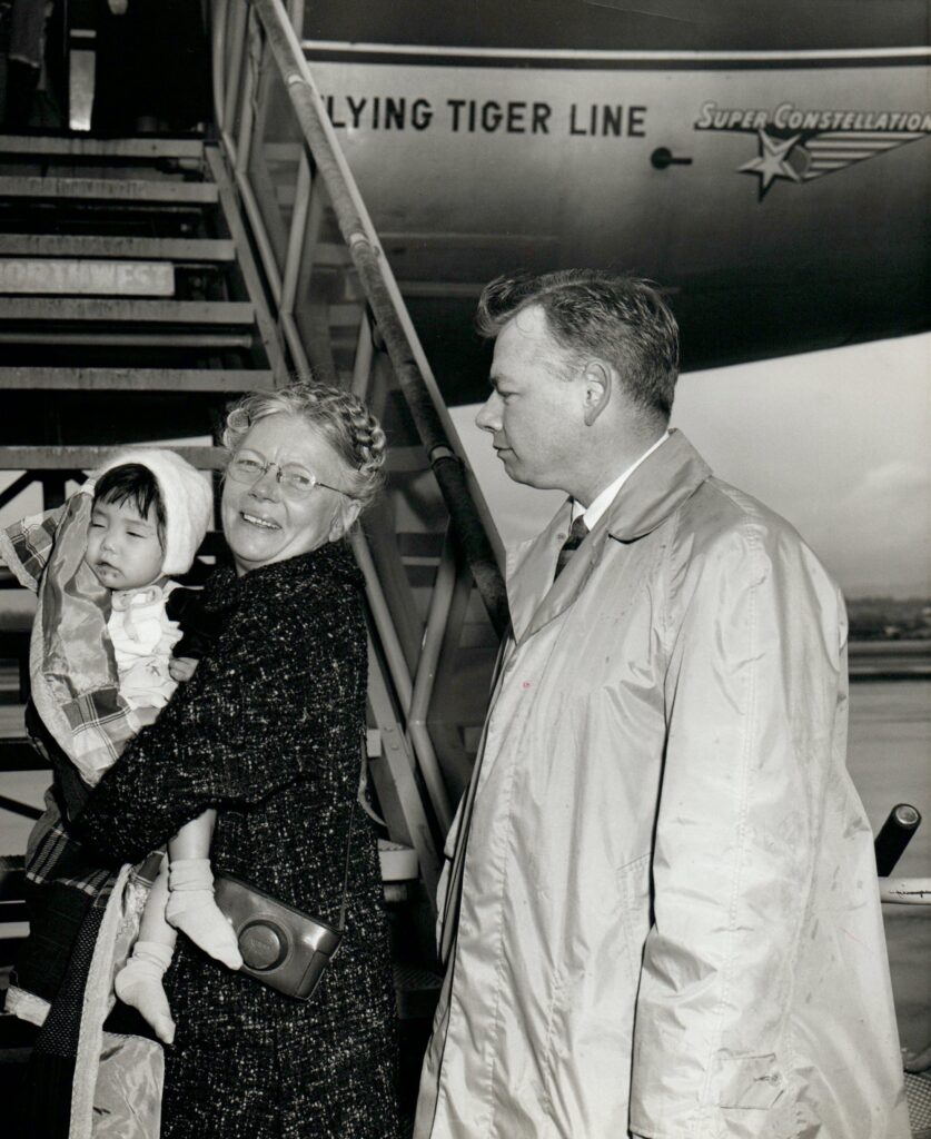 Bertha Holt boarding aircraft with orphan